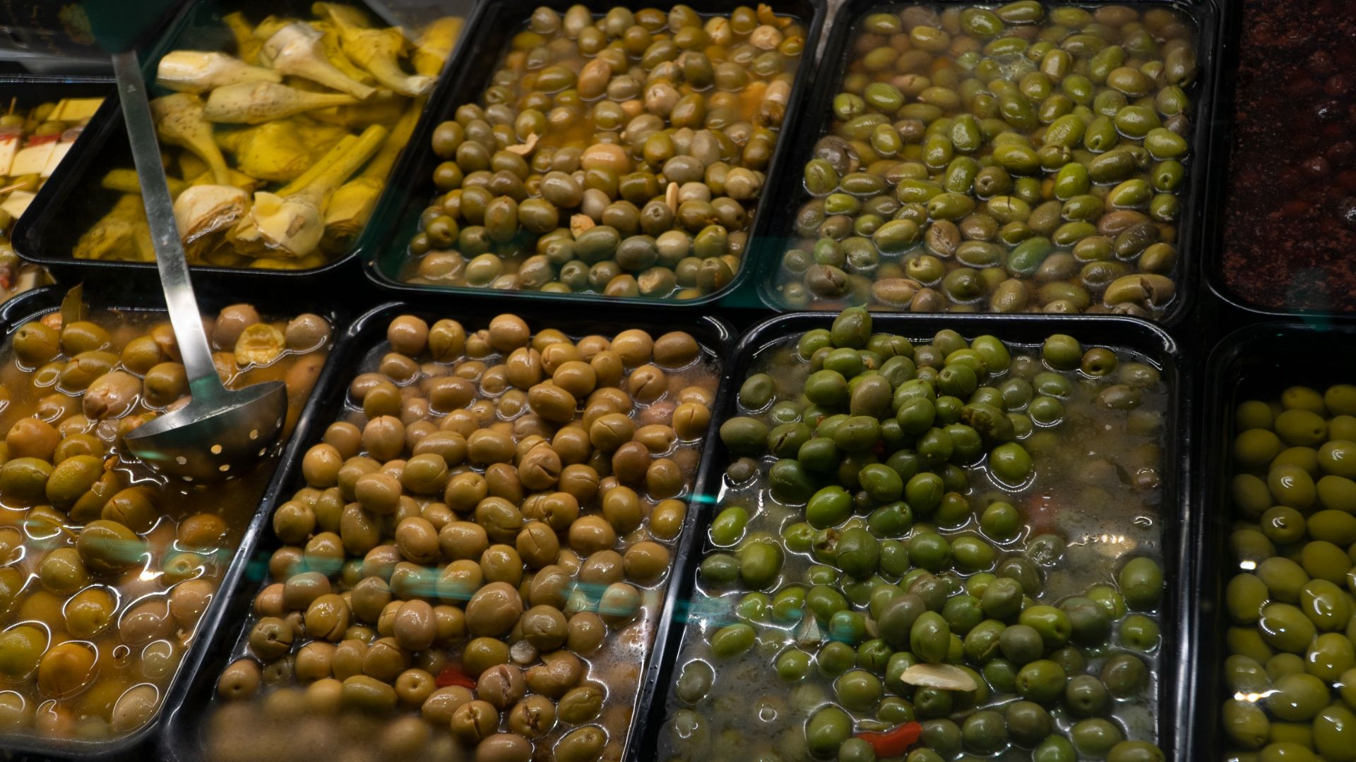 Categoría Encurtidos y Variantes: Bandejas con variedad de aceitunas aliñadas y alcachofas en conserva.