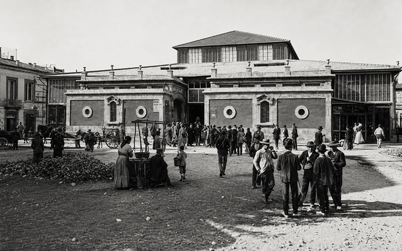 Vista histórica del Mercado Central de Almería con vecinos y actividad comercial frente al edificio